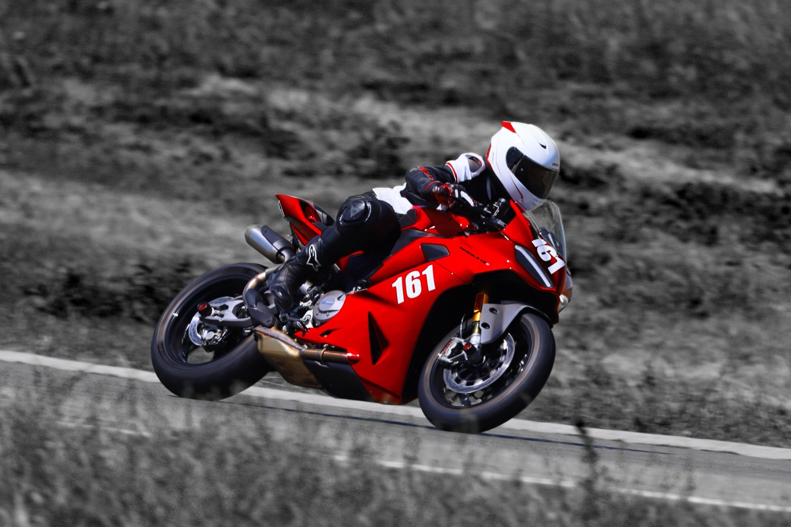 Natalia leaned over on a red Ducati Panigale, number 161, mid-corner on a race track